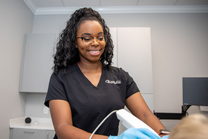 dental assistant taking itero scan of dental patients mouth